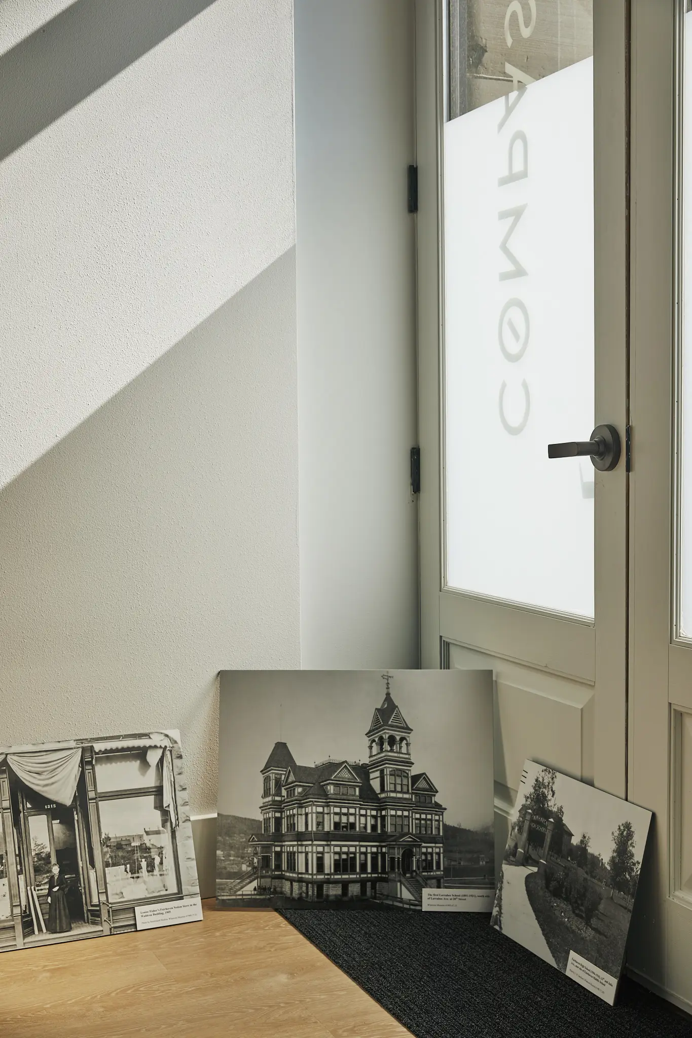 Old photographs of Fairhaven houses leaning against the wall inside the office door