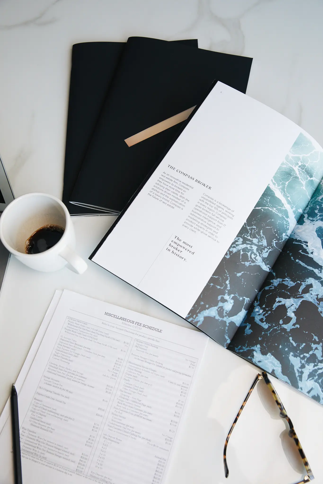 Notebooks, a printed sheet and a coffee cup from above