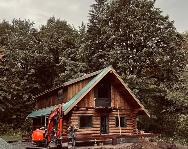 The cabin before the work, an excavator in the yard